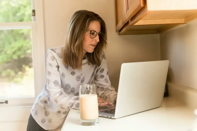 Woman on computer typing ChatGPT prompts for AI humanizers.